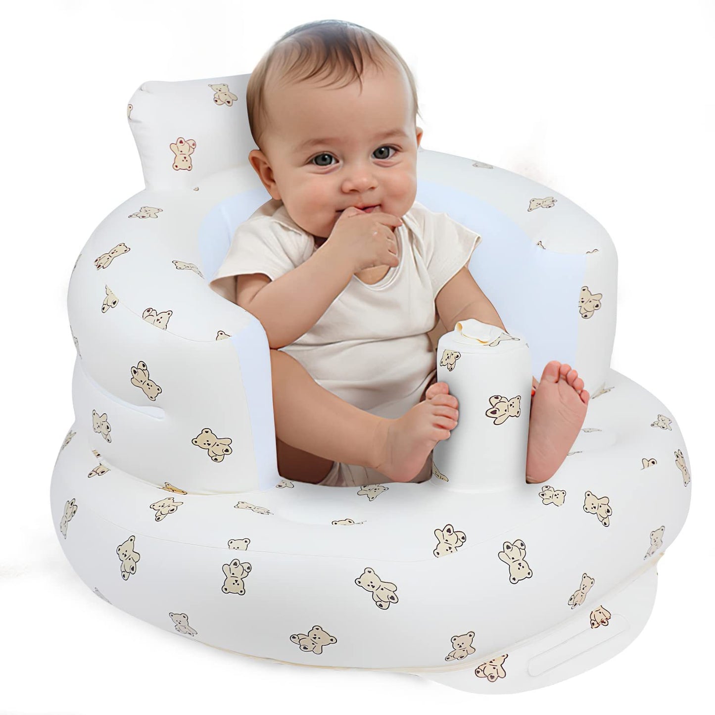 Baby sitting in a white cushion with teddy bear patterns on a white background